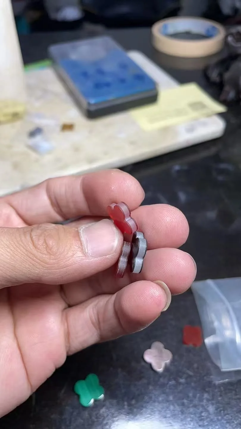 Disassembled layered motif showing two thin red stone faces and a thick cubic-zirconia core