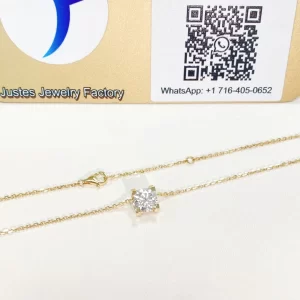 C de Cartier style pendant and chain displayed in front of the Justes logo and QR display board