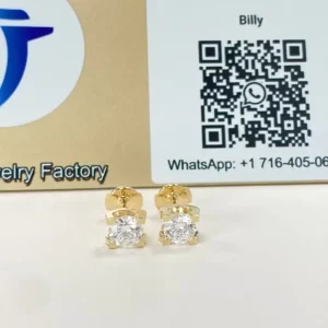 Pair of C de Cartier style stud earrings displayed in front of the Justes logo and QR display board