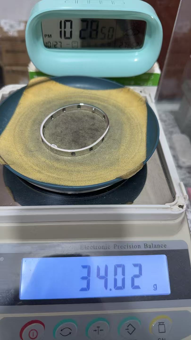 Replica bracelet on a digital scale displaying 34.02 g
