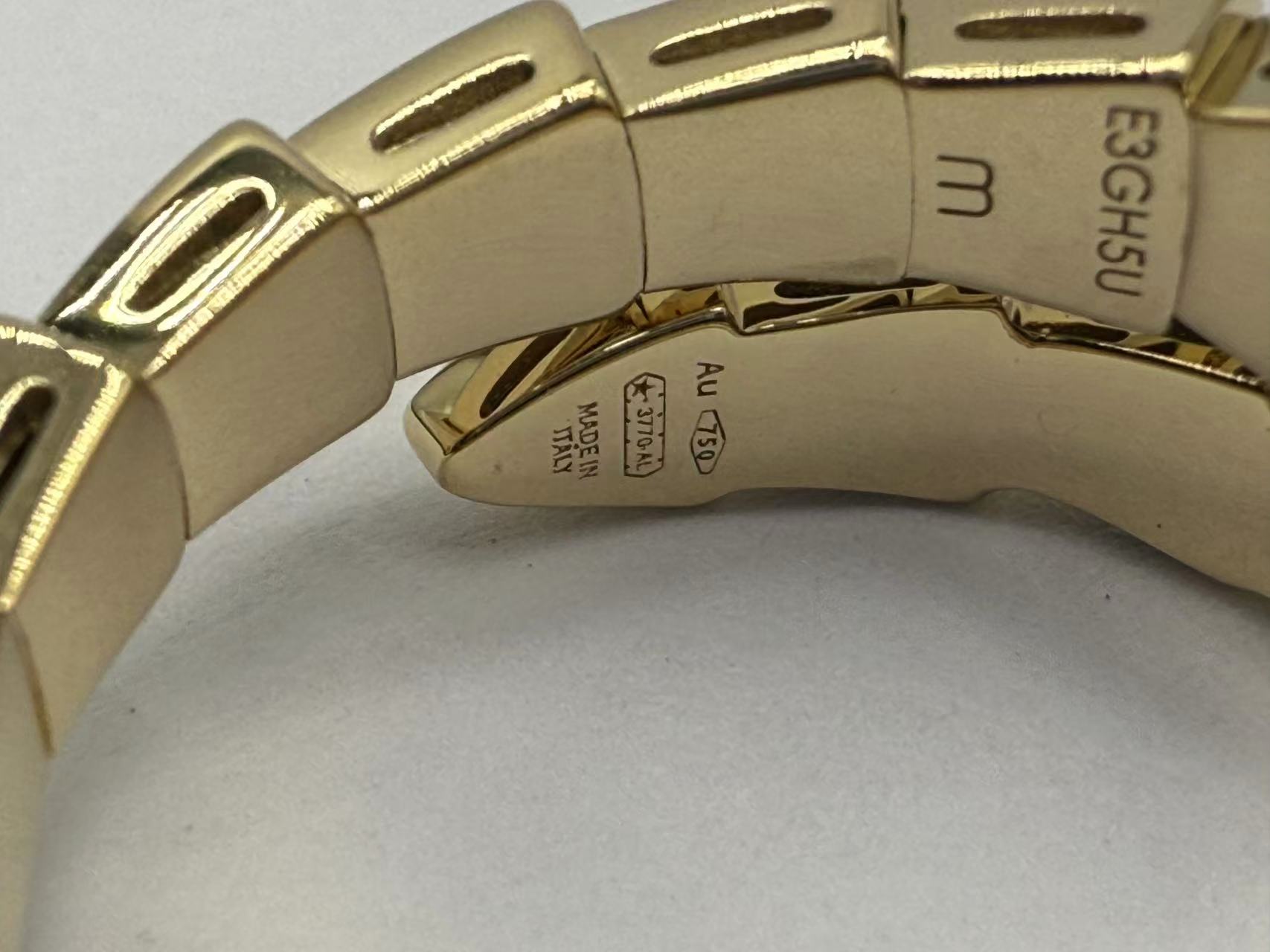 Angled detail of a Justes single-coil replica ring showing its inner curve and polished scale-like sections
